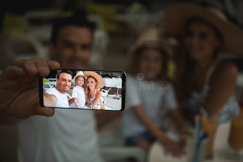 Vrolijke ouders die met kind op mobiel fotograferen stock fotografie Vrolijke ouders die met kind op mobiel fotograferen stock fotografie