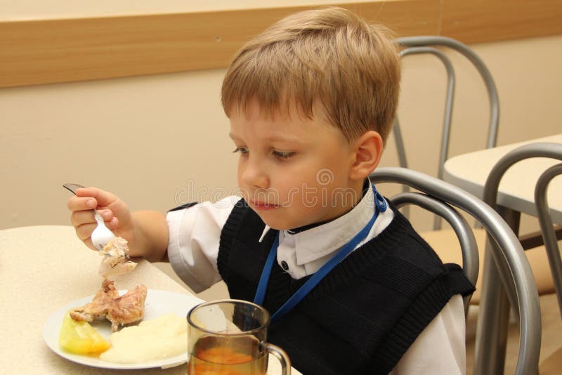 Vrolijke schooljongenzitting bij Lijst in Schoolcafetaria die Maaltijd eten drinkend sap - Rusland, Moskou, de eerste Middelbare royalty-vrije stock fotografie Vrolijke schooljongenzitting bij Lijst in Schoolcafetaria die Maaltijd eten drinkend sap - Rusland, Moskou, de eerste Middelbare royalty-vrije stock fotografie