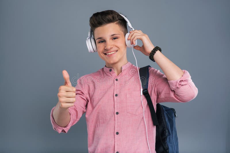 Vrolijke tienerschooljongen die van de muziek genieten royalty-vrije stock foto Vrolijke tienerschooljongen die van de muziek genieten royalty-vrije stock foto