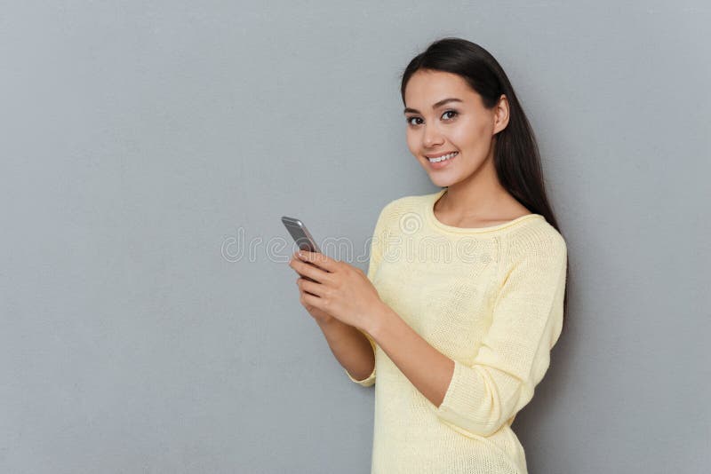 Vrolijke vrij jonge vrouw die en celtelefoon bevinden zich met behulp van royalty-vrije stock foto's Vrolijke vrij jonge vrouw die en celtelefoon bevinden zich met behulp van royalty-vrije stock foto's
