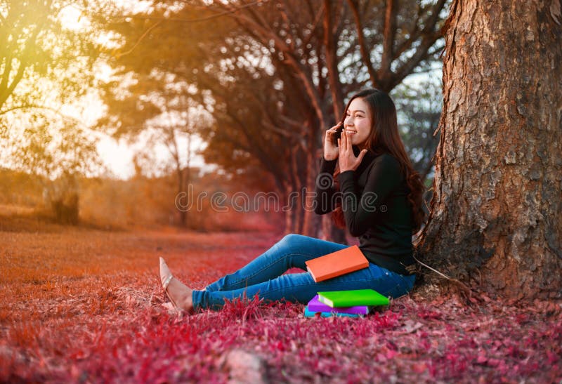 Vrolijke vrouw die op mobiele telefoon in park spreken stock afbeelding Vrolijke vrouw die op mobiele telefoon in park spreken stock afbeelding