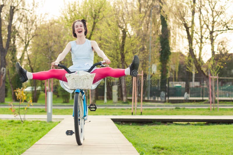 Vrolijke vrouwen berijdende fiets met haar benen in de lucht royalty-vrije stock foto Vrolijke vrouwen berijdende fiets met haar benen in de lucht royalty-vrije stock foto