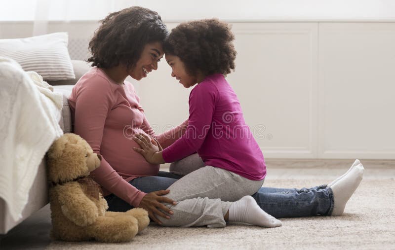 Vrolijke zwarte vrouw en haar schattige dochter die thuis vastzit