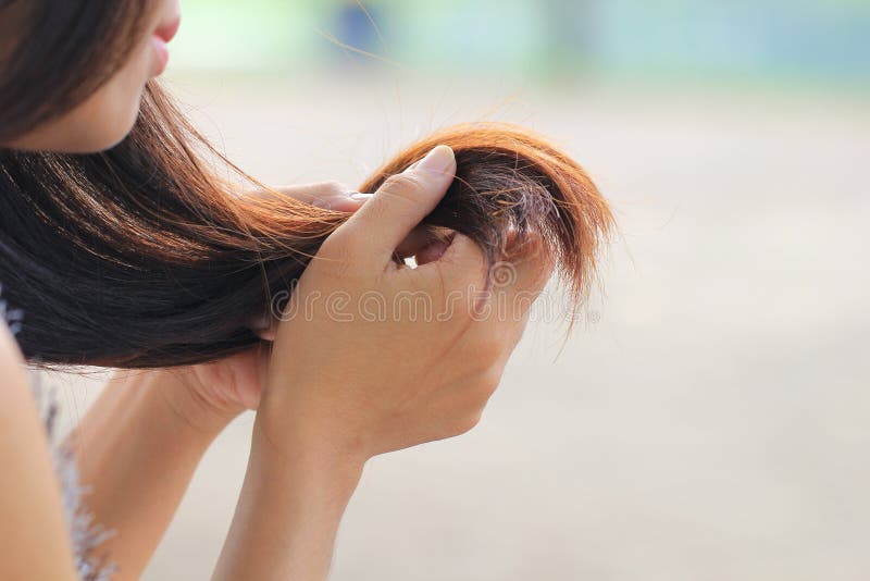 Vrouw die beschadigde verdelende einden van haar bekijken, Haircare-concept royalty-vrije stock foto's Vrouw die beschadigde verdelende einden van haar bekijken, Haircare-concept royalty-vrije stock foto's