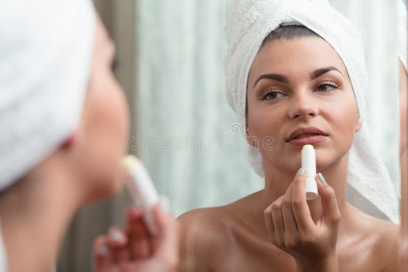 Vrouw die beschermende lippenstift toepassen stock afbeeldingen Vrouw die beschermende lippenstift toepassen stock afbeeldingen