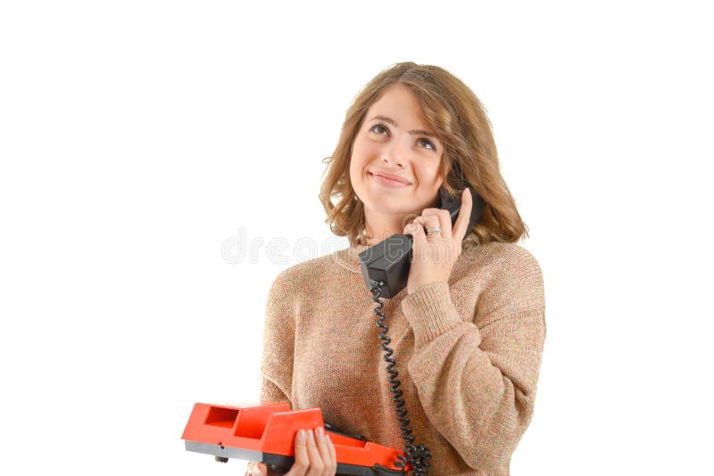 Vrouw die bij een oude die telefoon spreekt, op witte achtergrond wordt geïsoleerd royalty-vrije stock fotografie Vrouw die bij een oude die telefoon spreekt, op witte achtergrond wordt geïsoleerd royalty-vrije stock fotografie