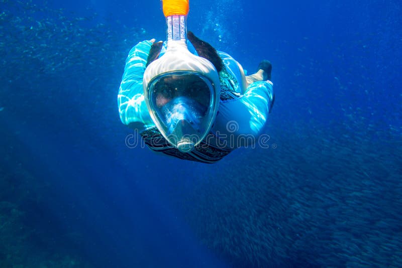 Vrouw die in blauwe overzees zwemt Meisje die in volledig-gezichtsmasker snorkelen Snorkel met de onderwaterfoto van de vissensch royalty-vrije stock fotografie Vrouw die in blauwe overzees zwemt Meisje die in volledig-gezichtsmasker snorkelen Snorkel met de onderwaterfoto van de vissensch royalty-vrije stock fotografie