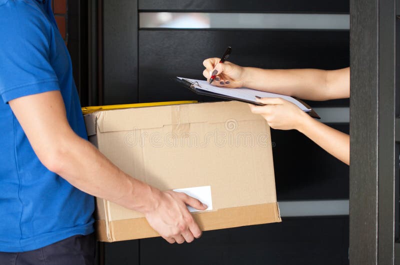 Delivery guy holding package while woman is signing documents. Delivery guy holding package while woman is signing documents