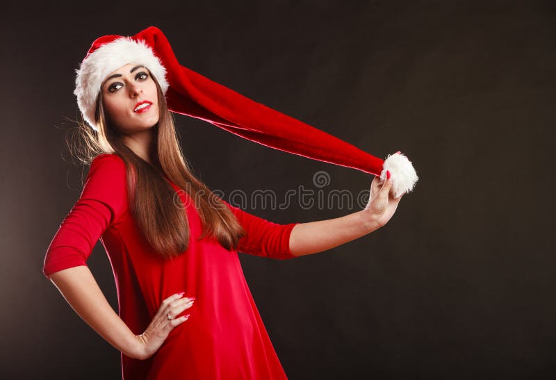 Vrouw die de hoed van de Kerstman op zwarte dragen stock fotografie Vrouw die de hoed van de Kerstman op zwarte dragen stock fotografie
