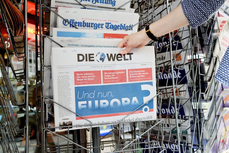 Vrouw die Die Welt-krant met het schokken van krantekop over Br kopen stock afbeelding Vrouw die Die Welt-krant met het schokken van krantekop over Br kopen stock afbeelding