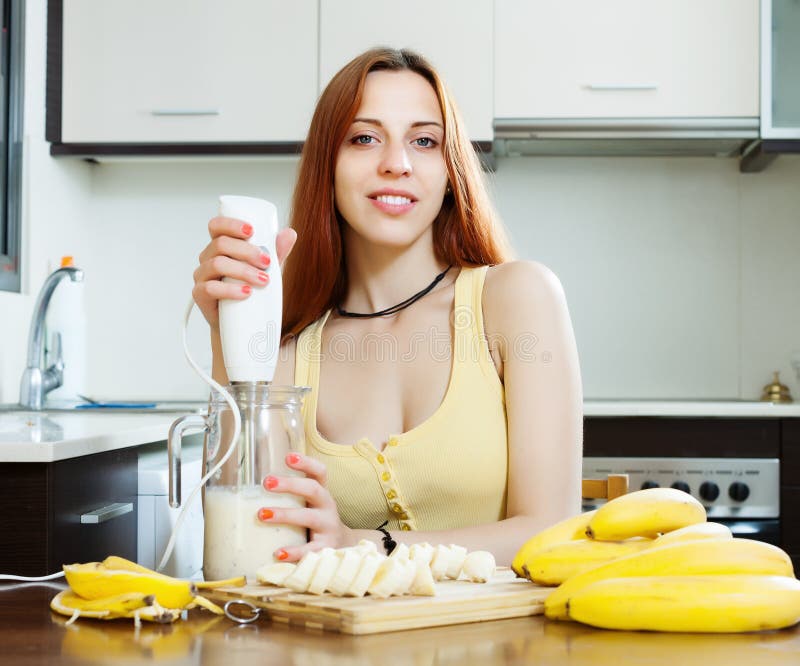 Vrouw die dranken van bananen en melk maken
