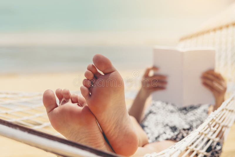 Vrouw die een boek op hangmatstrand lezen in de vakantie van de vrije tijdzomer royalty-vrije stock afbeelding Vrouw die een boek op hangmatstrand lezen in de vakantie van de vrije tijdzomer royalty-vrije stock afbeelding