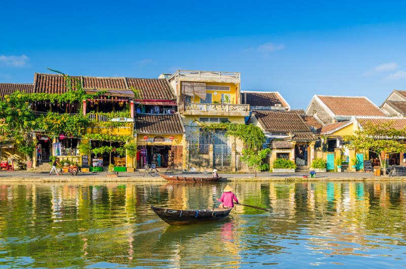 Vrouw die een rivier op een boot in Hoi An kruisen royalty-vrije stock foto Vrouw die een rivier op een boot in Hoi An kruisen royalty-vrije stock foto