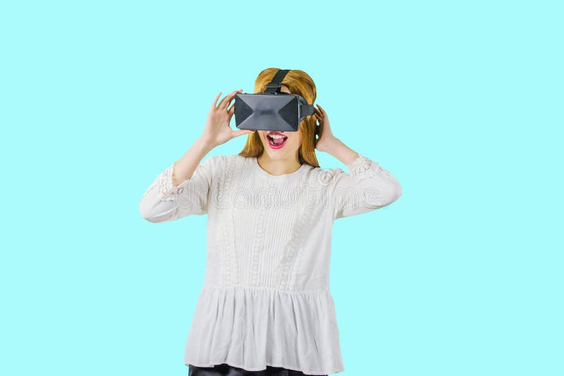 Vrouw die een vrhoofdtelefoon dragen Jonge vrouw in een witte blouse met een VR-hoofddeksel, een stuitende blik van paniek nieuw stock afbeelding Vrouw die een vrhoofdtelefoon dragen Jonge vrouw in een witte blouse met een VR-hoofddeksel, een stuitende blik van paniek nieuw stock afbeelding