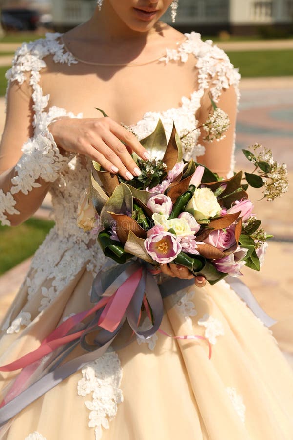 Vrouw die in elegante huwelijkskleding luxueus huwelijk houden bouque royalty-vrije stock foto Vrouw die in elegante huwelijkskleding luxueus huwelijk houden bouque royalty-vrije stock foto