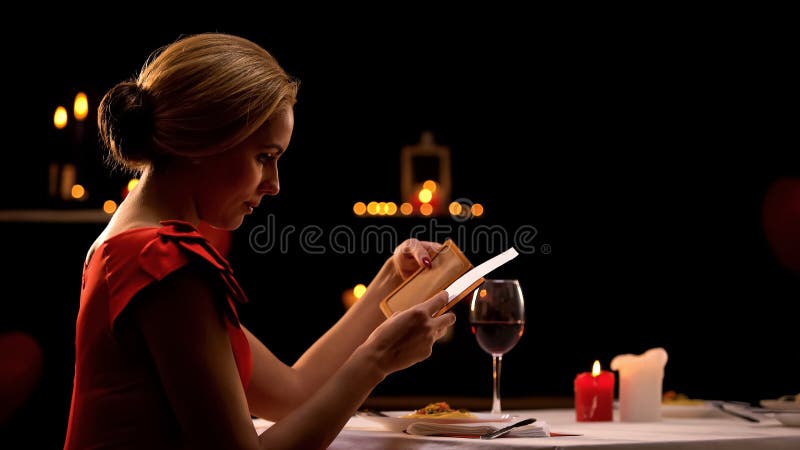 Vrouw die in elegante kleding de restaurantrekening bekijken, die alleen diner hebben, verdeelt royalty-vrije stock afbeeldingen Vrouw die in elegante kleding de restaurantrekening bekijken, die alleen diner hebben, verdeelt royalty-vrije stock afbeeldingen