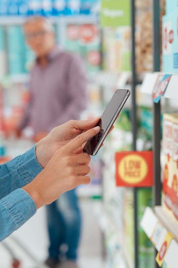 Vrouw die en haar telefoon met behulp van winkelen stock fotografie Vrouw die en haar telefoon met behulp van winkelen stock fotografie