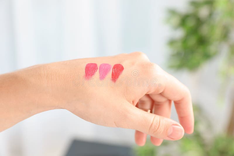 Vrouw die en lipglosskleur op hand testen kiezen royalty-vrije stock fotografie Vrouw die en lipglosskleur op hand testen kiezen royalty-vrije stock fotografie