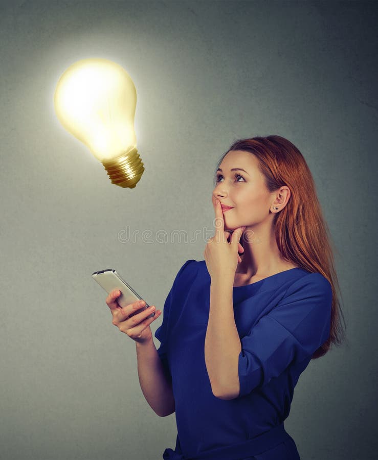 Vrouw die gebruikend mobiele telefoon die omhoog gloeilamp bekijken texting Het concept van het technologieidee royalty-vrije stock foto Vrouw die gebruikend mobiele telefoon die omhoog gloeilamp bekijken texting Het concept van het technologieidee royalty-vrije stock foto