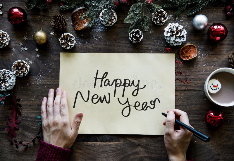 Vrouw die Gelukkig Nieuwjaar op een Kerstkaart schrijven royalty-vrije stock afbeeldingen Vrouw die Gelukkig Nieuwjaar op een Kerstkaart schrijven royalty-vrije stock afbeeldingen