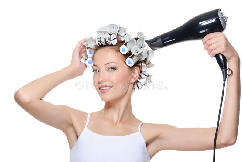 Happy beautiful young woman drying her head in hair-curlers. Happy beautiful young woman drying her head in hair-curlers