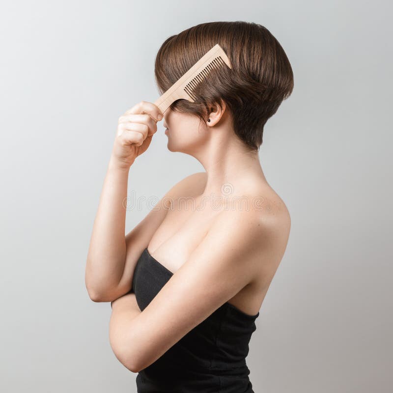 Vrouw die haar haar met een houten kam borstelen royalty-vrije stock afbeelding Vrouw die haar haar met een houten kam borstelen royalty-vrije stock afbeelding