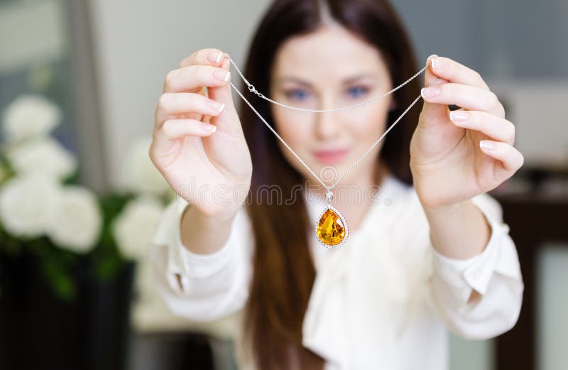 Vrouw die halsband met gele saffier houden royalty-vrije stock fotografie Vrouw die halsband met gele saffier houden royalty-vrije stock fotografie