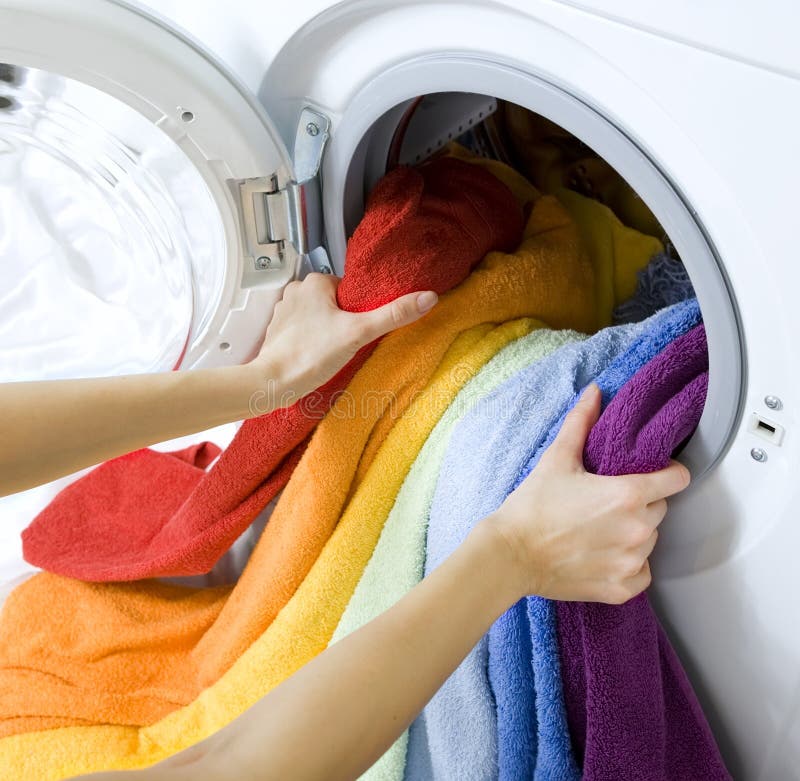 Vrouw die kleren van wasmachine nemen royalty-vrije stock fotografie Vrouw die kleren van wasmachine nemen royalty-vrije stock fotografie