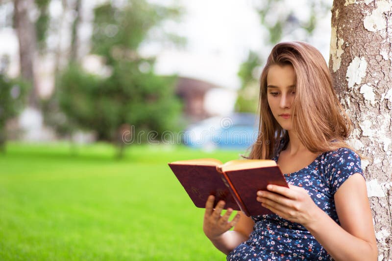 Vrouw die lezend een boek terwijl het zitten in campus bestuderen royalty-vrije stock afbeelding Vrouw die lezend een boek terwijl het zitten in campus bestuderen royalty-vrije stock afbeelding