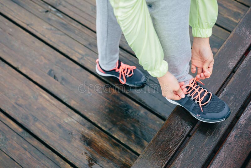 Vrouw die lopende sportschoenen rijgen stock foto Vrouw die lopende sportschoenen rijgen stock foto