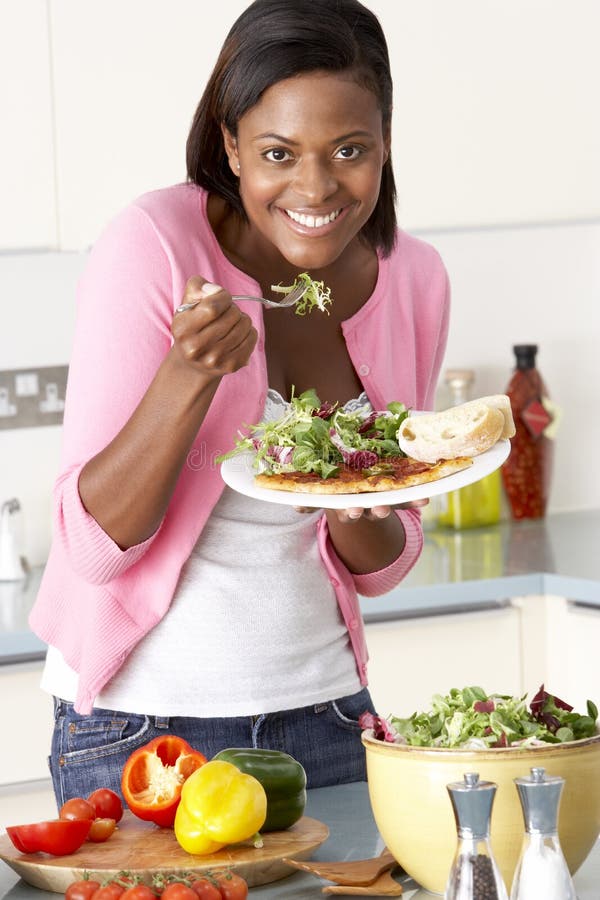 Vrouw die Maaltijd in Keuken eet royalty-vrije stock foto Vrouw die Maaltijd in Keuken eet royalty-vrije stock foto