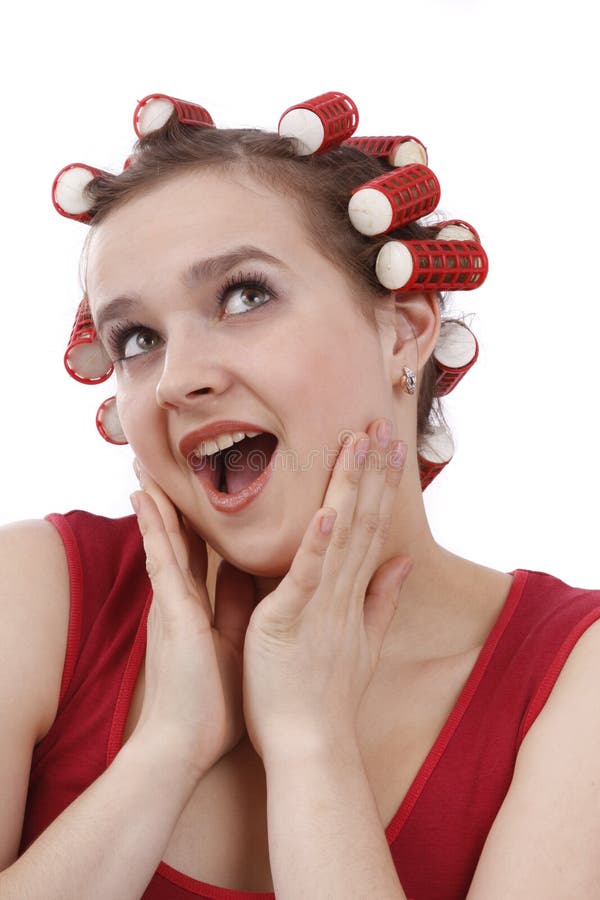 Young woman with hair rollers isolated on white. Young beautiful surprised woman with hair rollers in curls isolated on white. Nice girl with red hair-curlers. Isolated on white in studio. Young woman with hair rollers isolated on white. Young beautiful surprised woman with hair rollers in curls isolated on white. Nice girl with red hair-curlers. Isolated on white in studio.