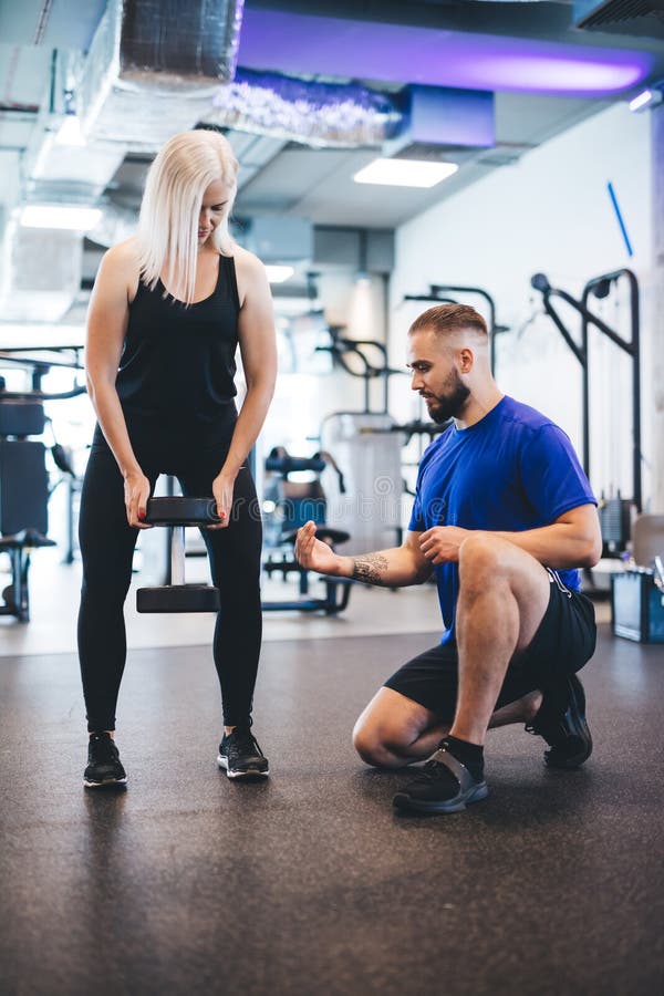 Vrouw die met persoonlijke trainer uitoefent stock afbeelding Vrouw die met persoonlijke trainer uitoefent stock afbeelding