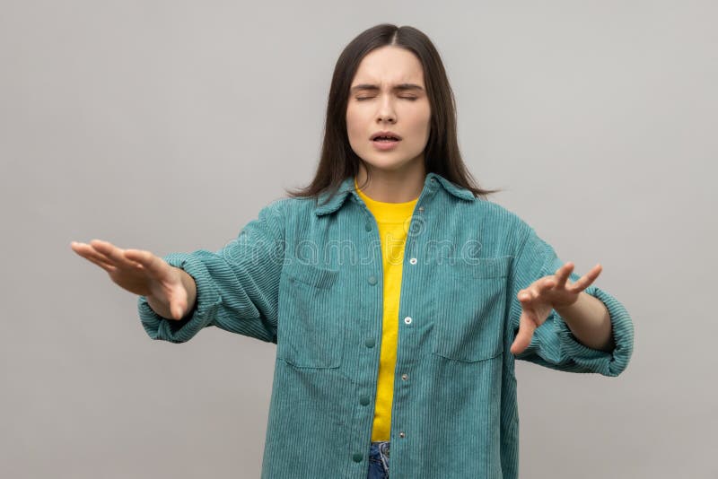 I can&#x27;t see. Portrait of woman walking with outstretched hands, blind or disoriented in darkness, having eyesight problems, wearing casual style jacket. Indoor studio shot isolated on gray background. I can&#x27;t see. Portrait of woman walking with outstretched hands, blind or disoriented in darkness, having eyesight problems, wearing casual style jacket. Indoor studio shot isolated on gray background.