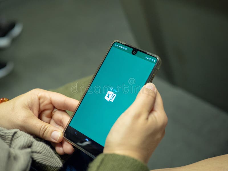 Vrouw die Microsoft Office 365 Excel app met embleem op Android-het scherm openen terwijl het omzetten op metro stock fotografie Vrouw die Microsoft Office 365 Excel app met embleem op Android-het scherm openen terwijl het omzetten op metro stock fotografie