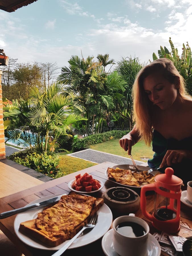 Vrouw die ochtendontbijt op vakantie eten stock afbeelding Vrouw die ochtendontbijt op vakantie eten stock afbeelding