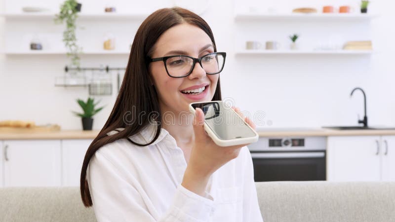 Vrouw die op een bank ontspannen en smartphone gebruikt voor het opnemen van gesprekken.