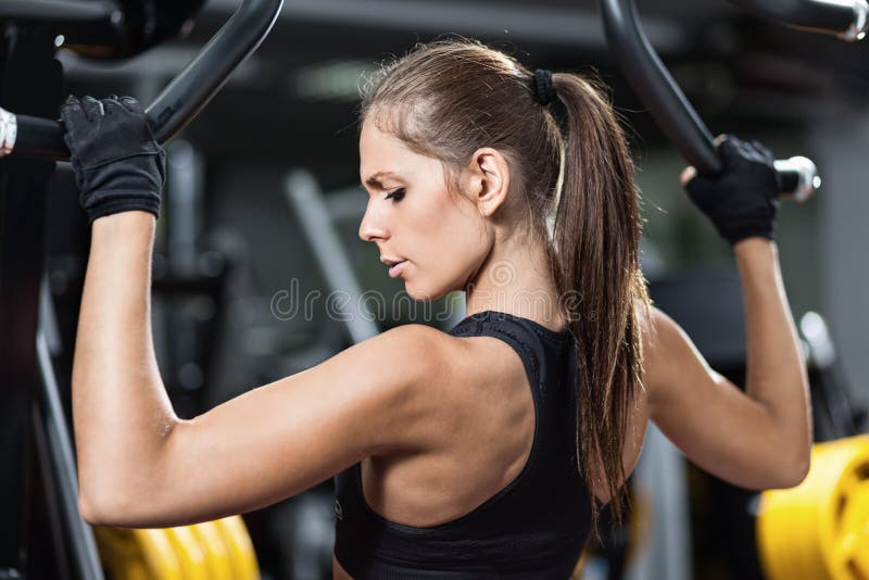 Vrouw die aan het trainen is op een krachttoestel royalty-vrije stock fotografie