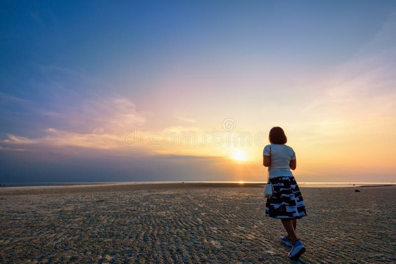 Vrouw die op het strand bij Zonsondergang wandelen stock foto Vrouw die op het strand bij Zonsondergang wandelen stock foto