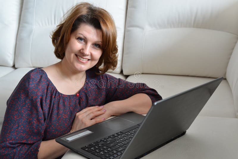 Vrouw die op middelbare leeftijd bij computer thuis werken royalty-vrije stock foto Vrouw die op middelbare leeftijd bij computer thuis werken royalty-vrije stock foto