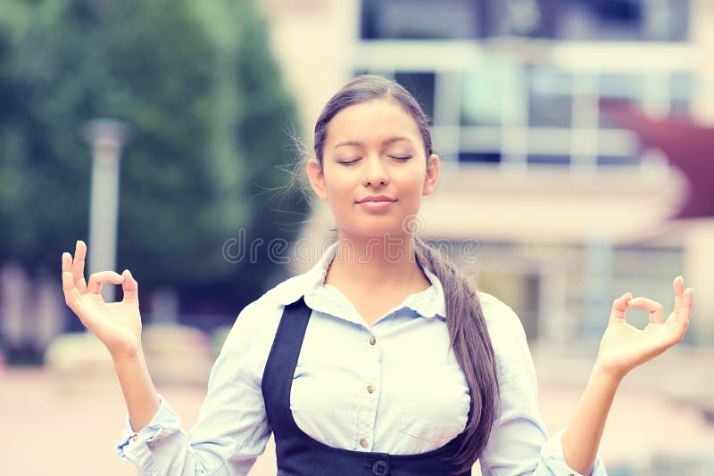 Portrait happy young business woman in blue shirt eyes closed hands raised in air relaxing meditating taking deep breath isolated outside city background. Corporate life style. Stress relief technique. Portrait happy young business woman in blue shirt eyes closed hands raised in air relaxing meditating taking deep breath isolated outside city background. Corporate life style. Stress relief technique