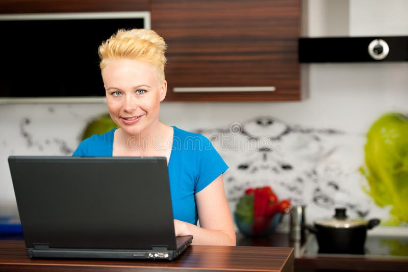 Vrouw die post controleren op laptop in keuken stock fotografie Vrouw die post controleren op laptop in keuken stock fotografie