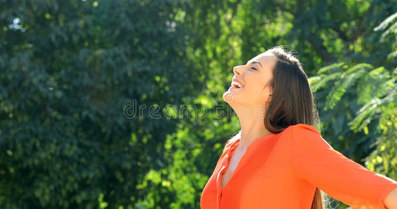 Vrouw die in sinaasappel verse lucht in een park ademen