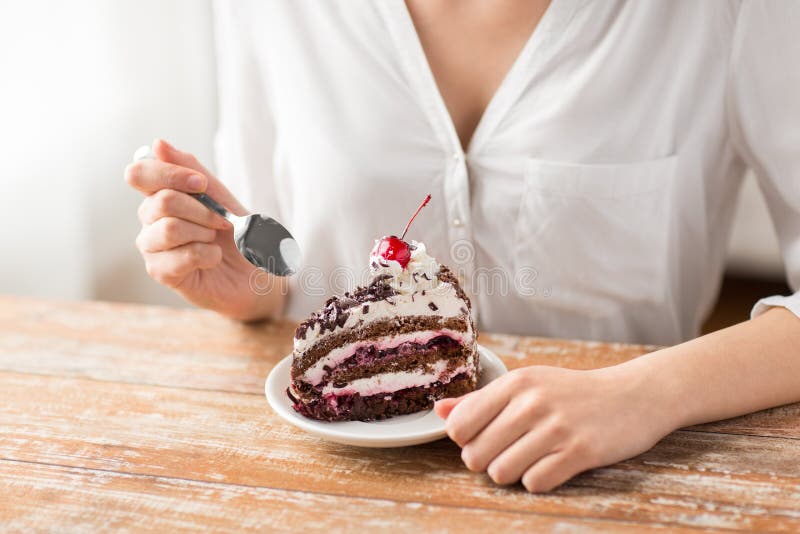 Vrouw die stuk van laagcake eten met kers royalty-vrije stock afbeeldingen Vrouw die stuk van laagcake eten met kers royalty-vrije stock afbeeldingen