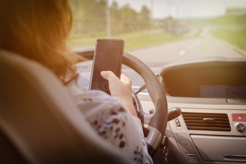 Vrouw die telefoon met behulp van terwijl het drijven van de auto stock foto's Vrouw die telefoon met behulp van terwijl het drijven van de auto stock foto's