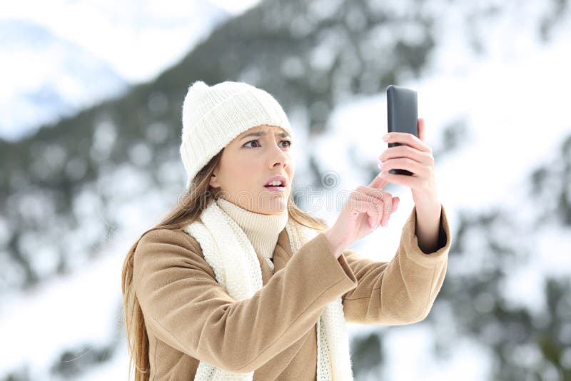 Vrouw die telefoondekking zoeken in de winter royalty-vrije stock foto Vrouw die telefoondekking zoeken in de winter royalty-vrije stock foto