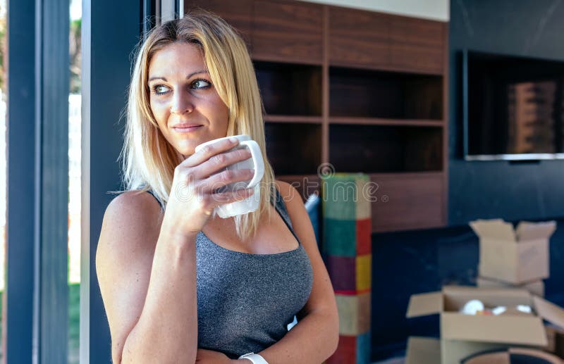 Vrouw die van het uitpakken van bewegende dozen rusten stock foto Vrouw die van het uitpakken van bewegende dozen rusten stock foto