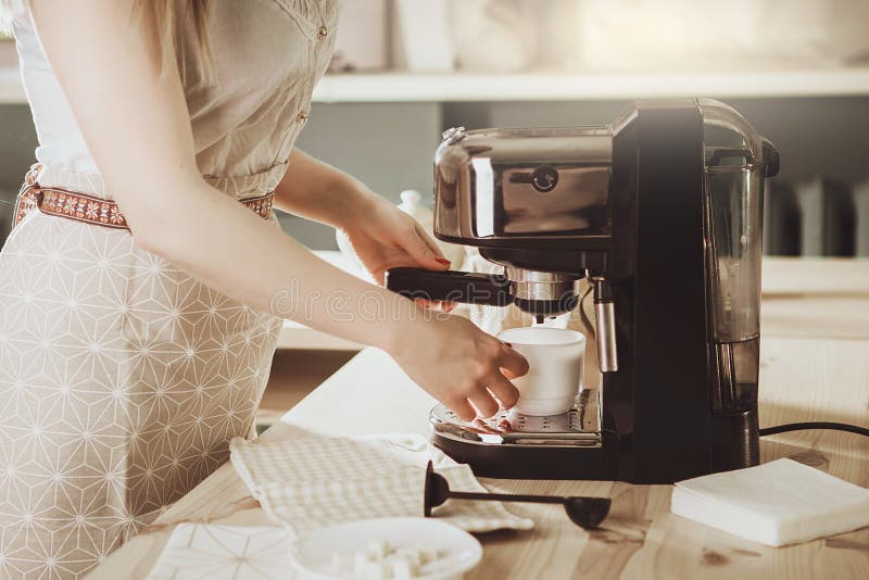 Vrouw die verse espresso in koffiezetapparaat maken de koffiemachine maakt stock afbeeldingen Vrouw die verse espresso in koffiezetapparaat maken de koffiemachine maakt stock afbeeldingen