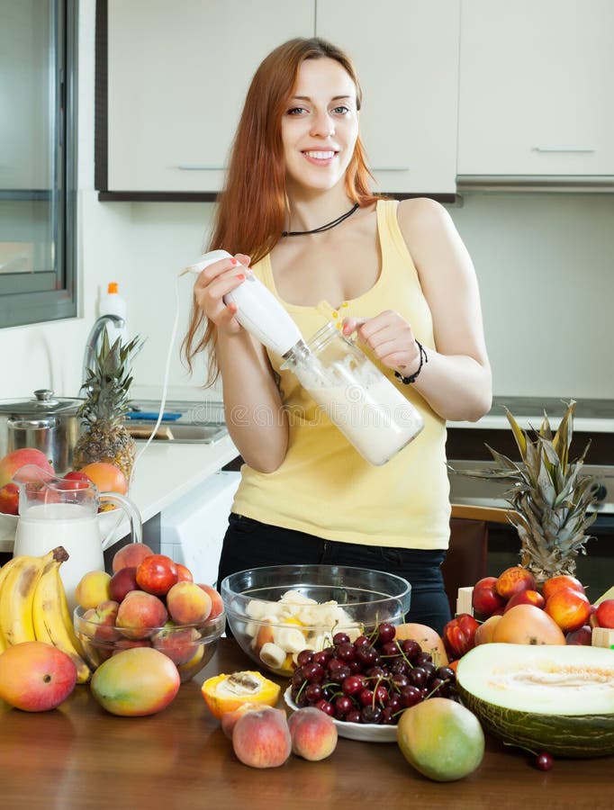 Vrouw die verse milkshake van vruchten maken