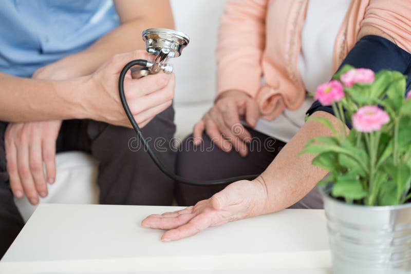 Woman suffering for hypertension having measured blood pressure. Woman suffering for hypertension having measured blood pressure